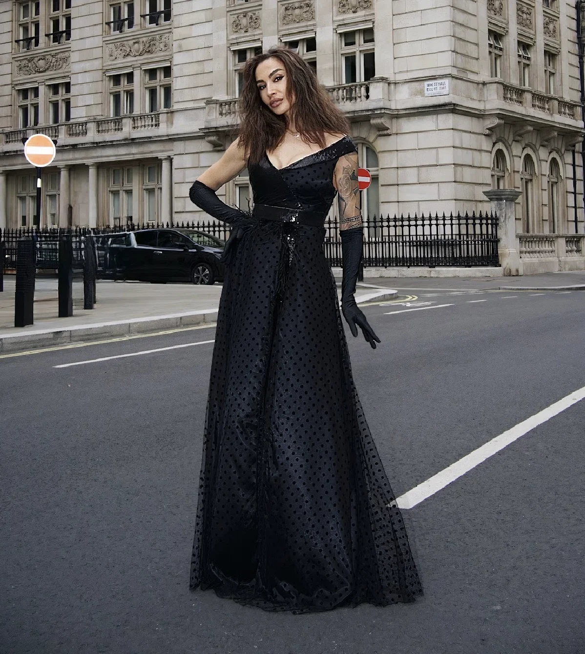 Bespoke Womenswear, a lady in a black long gown with long gloves, standing at a london street