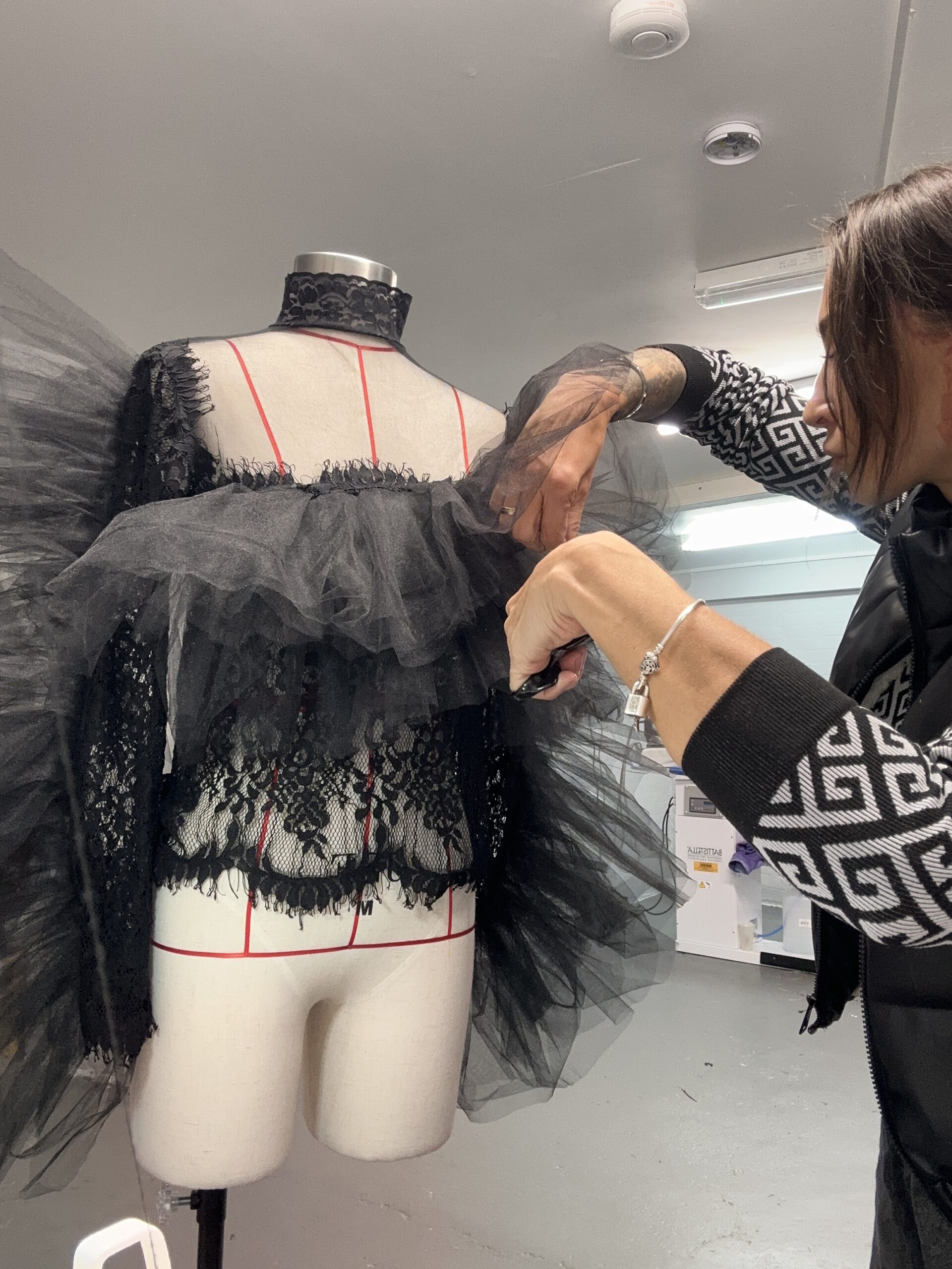a tailor alter a black blouse on a professional tailor mannequin