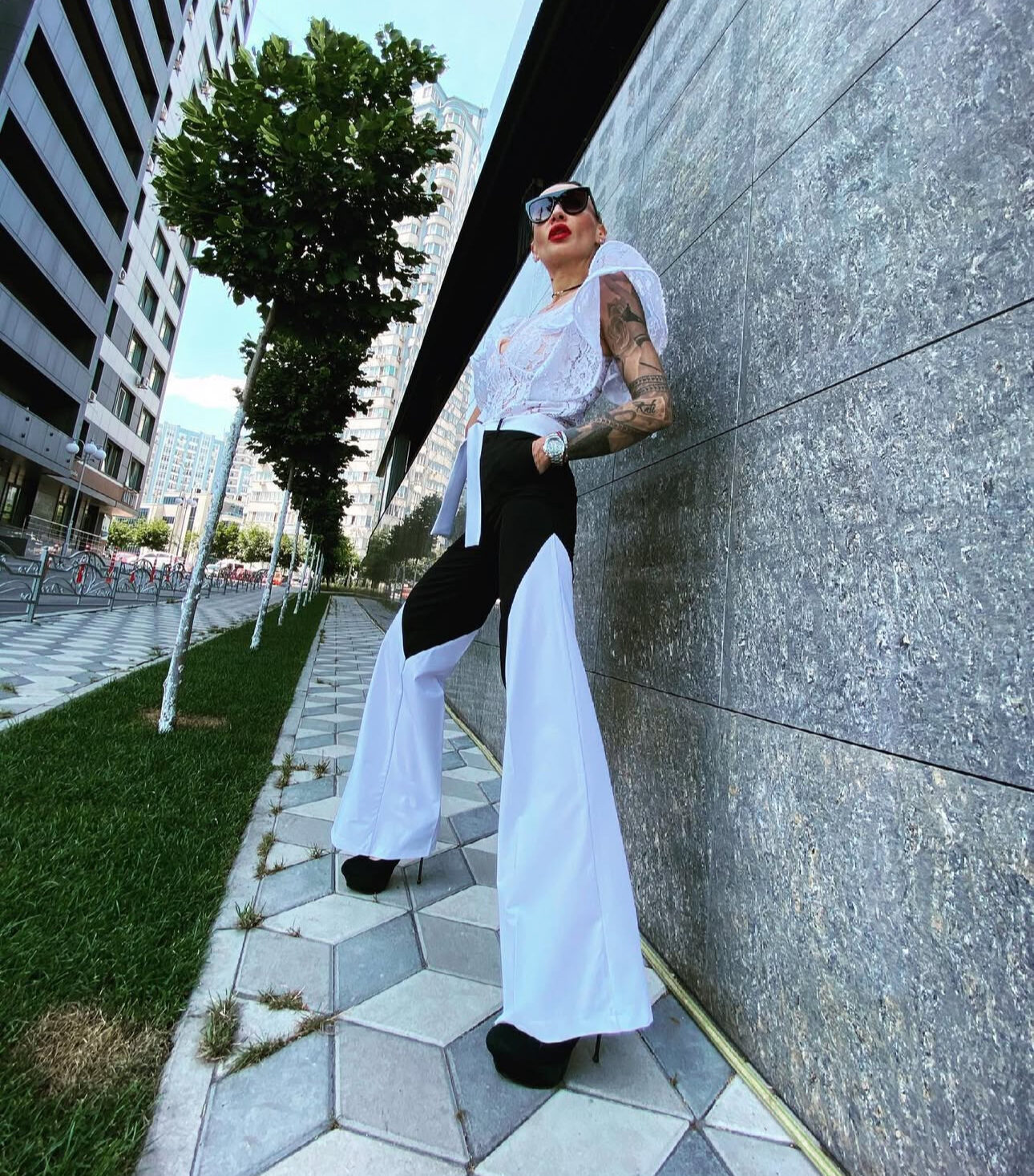 a lady standing near the wall in a fashion bespoke white pants, made by k&k couture