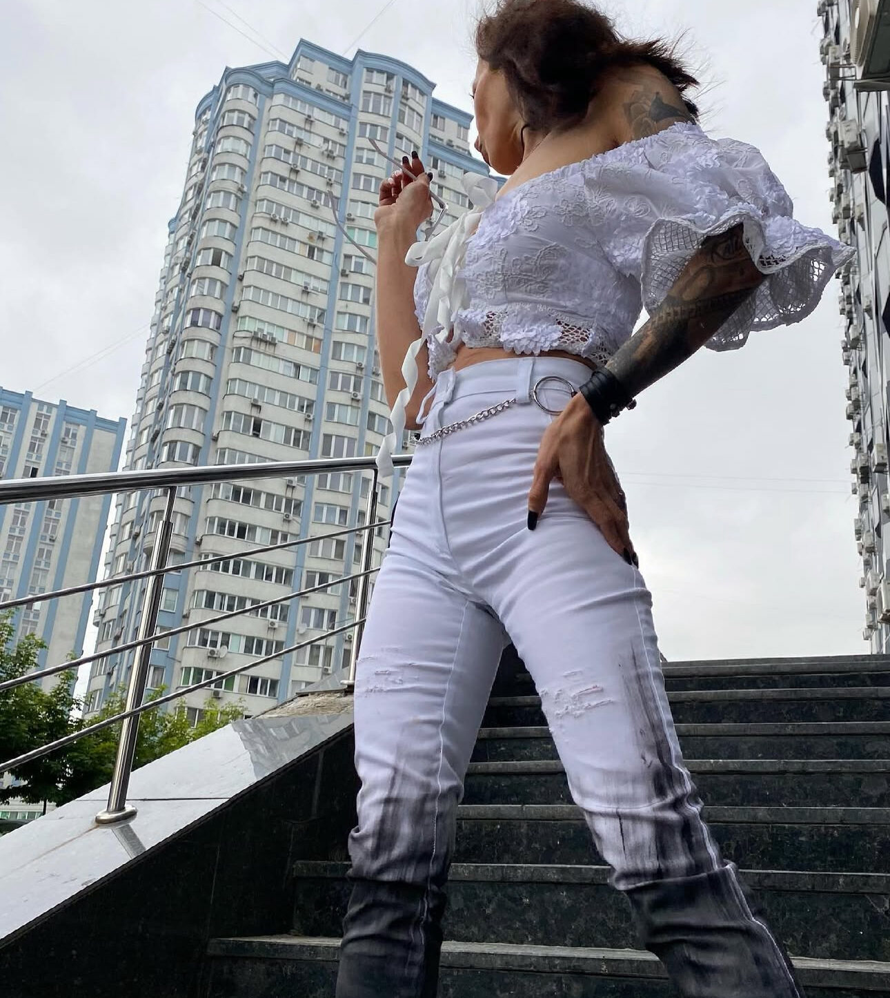 a lady in a bespoke white shirt made by k&k couture, standing on the stairs