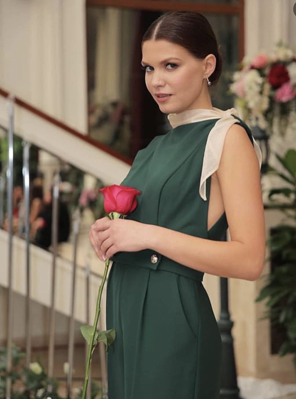 A woman wearing a bespoke wide-leg jumpsuit, standing in a stylish urban setting, made by k&k couture
