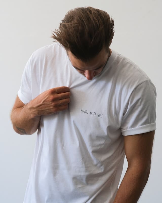 A man wearing a bespoke white T-shirt, tailored for a perfect fit.