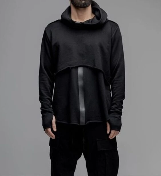 a man in a black, bespoke fashion sweatshirt, the sleeves cover the arms like continuous gloves, made by K&K Couture